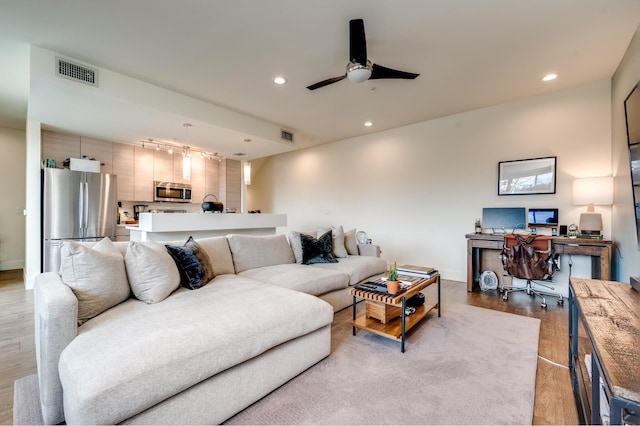 living room with light wood-type flooring and ceiling fan