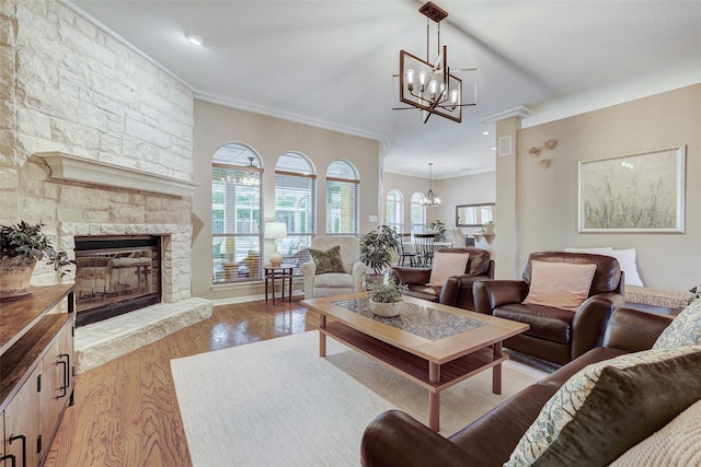 living room with ornamental molding, a healthy amount of sunlight, light wood-type flooring, and a fireplace