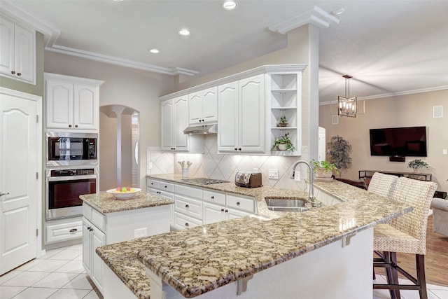 kitchen featuring sink, oven, a kitchen breakfast bar, kitchen peninsula, and built in microwave