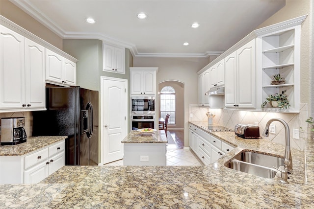 kitchen with black appliances, white cabinets, light stone countertops, and sink