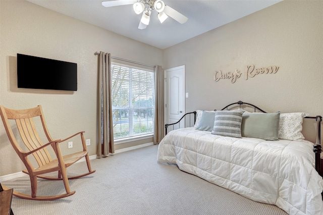 carpeted bedroom featuring multiple windows and ceiling fan