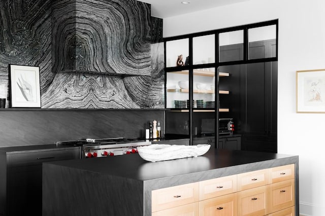 kitchen featuring light brown cabinetry and stove