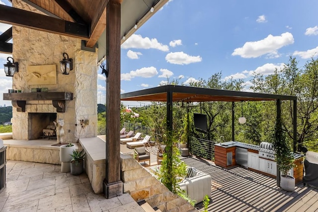 view of patio featuring area for grilling, a grill, and an outdoor stone fireplace