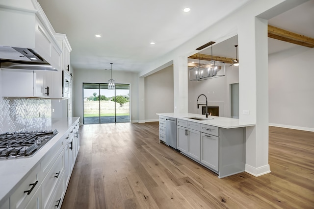 kitchen with beamed ceiling, white cabinets, and hanging light fixtures