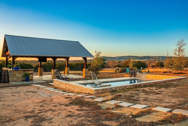 view of pool with a gazebo, a patio, exterior bar, and a mountain view