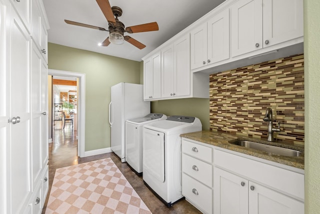 washroom featuring washing machine and dryer, ceiling fan, cabinets, and sink