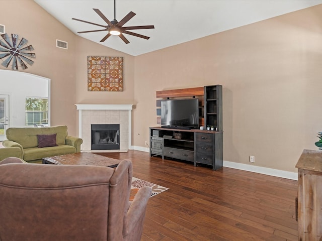 living room with ceiling fan, a tile fireplace, high vaulted ceiling, and dark hardwood / wood-style floors