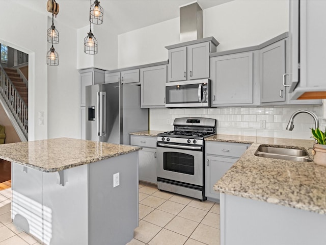 kitchen with hanging light fixtures, light tile patterned floors, backsplash, appliances with stainless steel finishes, and sink