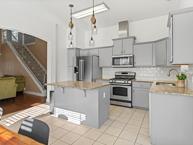 kitchen with sink, a center island, tasteful backsplash, light tile patterned floors, and appliances with stainless steel finishes