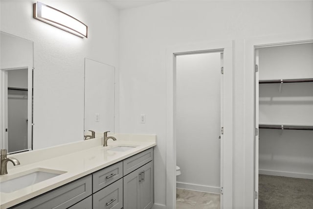 20714 Northland Dr, Lago Vista, TX 78645 - bathroom featuring double vanity, a spacious closet, and marble look tile flooring