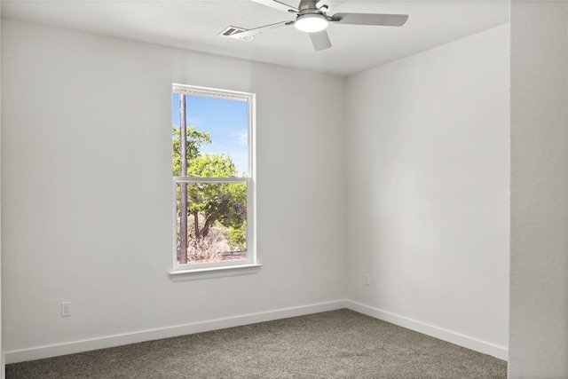 carpeted spare room with visible vents, baseboards, and a ceiling fan