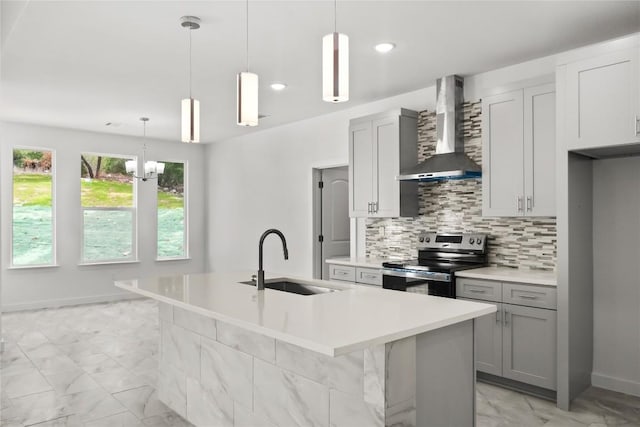 20714 Northland Dr, Lago Vista, TX 78645 - kitchen featuring stainless steel range with electric cooktop, wall chimney exhaust hood, decorative backsplash, light marble finish flooring, and a center island with sink