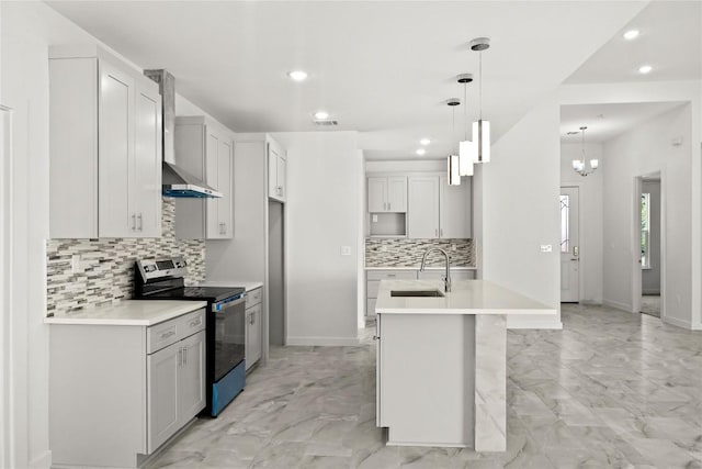 kitchen featuring marble finish floor, a sink, decorative light fixtures, stainless steel electric range, and wall chimney exhaust hood