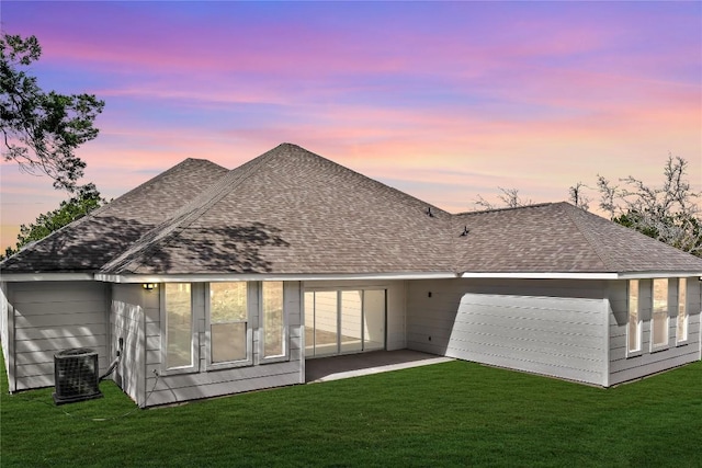 20714 Northland Dr, Lago Vista, TX 78645 - back of property at dusk with a shingled roof and a yard