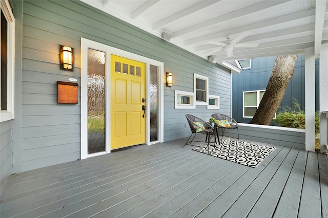 wooden terrace featuring covered porch and ceiling fan