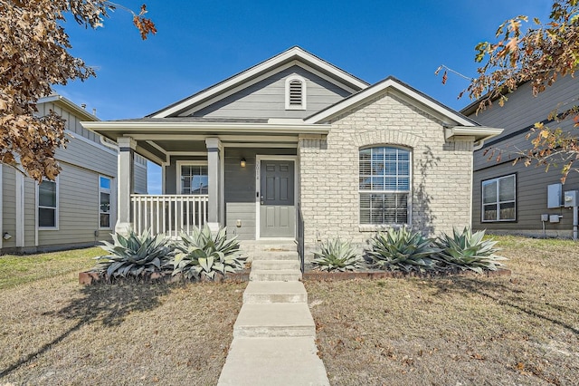 bungalow-style home with a front yard and covered porch