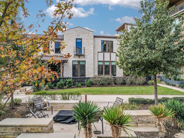 view of front of house featuring a front lawn and a patio