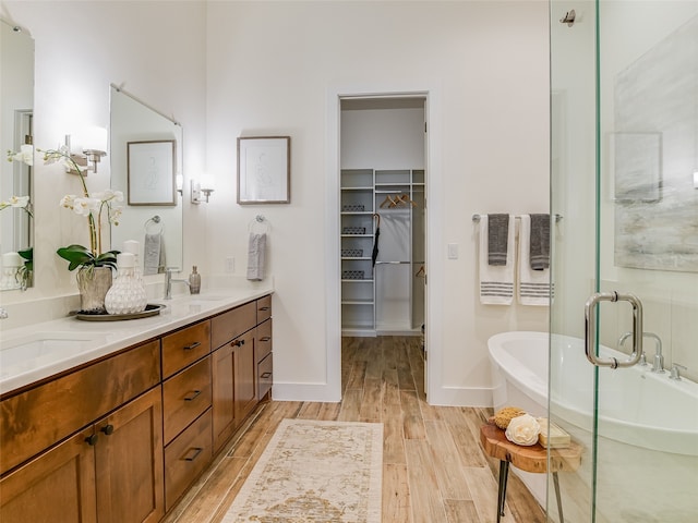 bathroom with vanity, hardwood / wood-style flooring, and a bathing tub