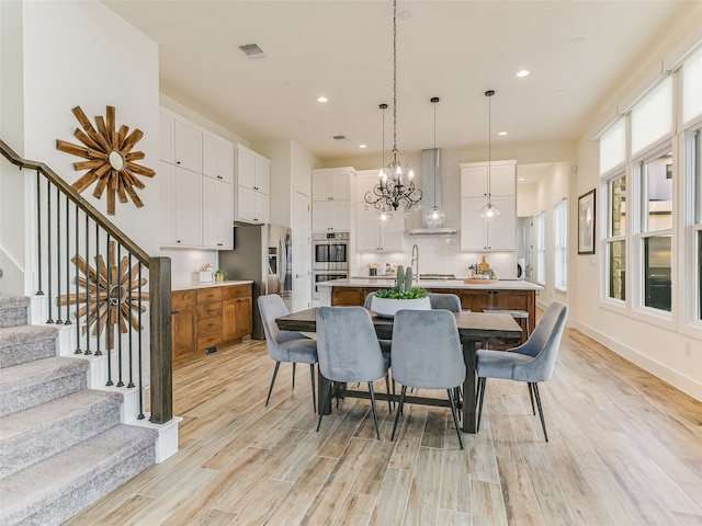 dining room with a notable chandelier and light wood-type flooring