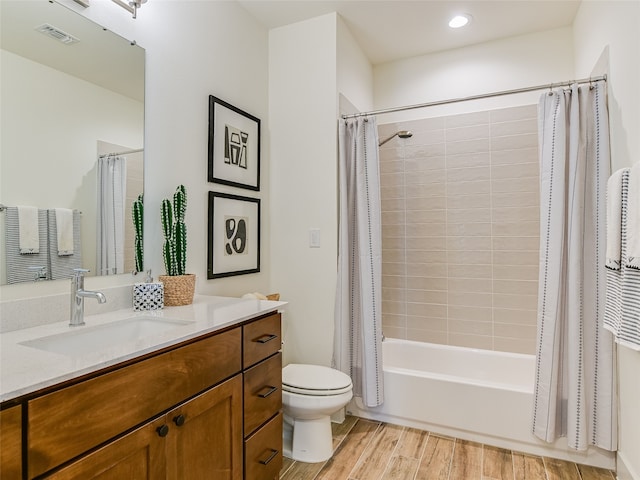 full bathroom featuring vanity, hardwood / wood-style floors, toilet, and shower / bath combo