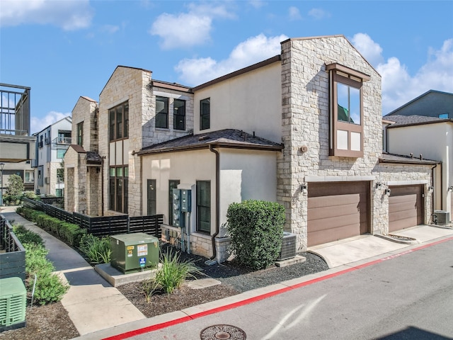 view of front of property featuring a garage and central AC unit