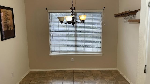 unfurnished dining area with a notable chandelier and tile patterned floors