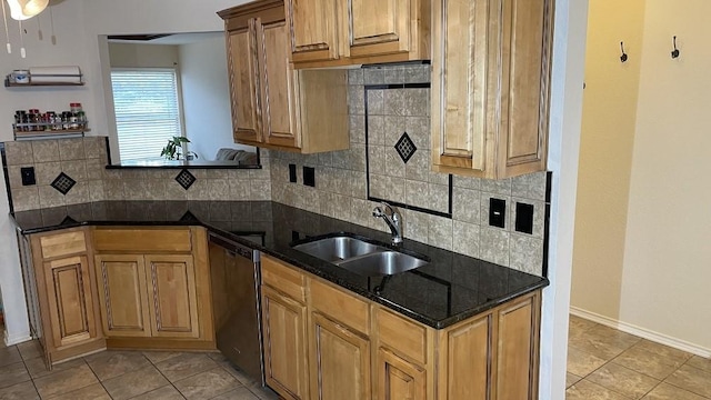 kitchen with dishwasher, light tile patterned floors, dark stone counters, sink, and backsplash