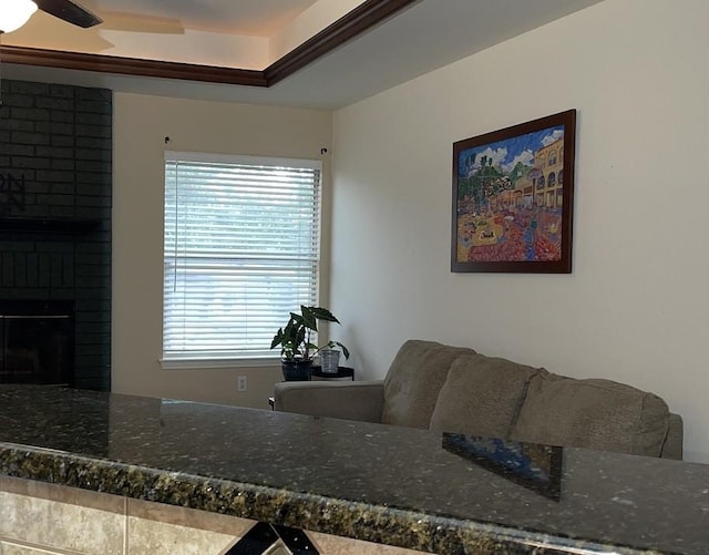 living room with a fireplace, ceiling fan, and a wealth of natural light