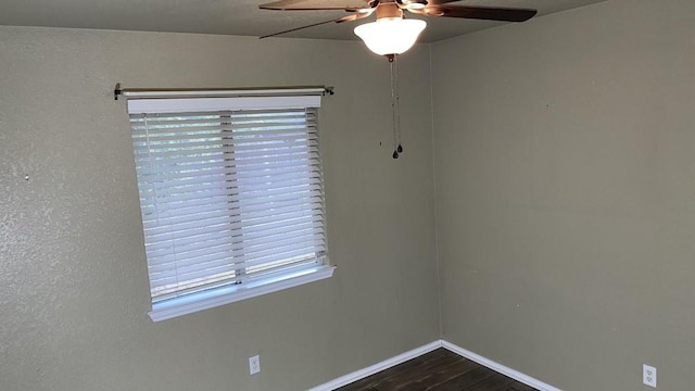 empty room with ceiling fan and dark hardwood / wood-style flooring