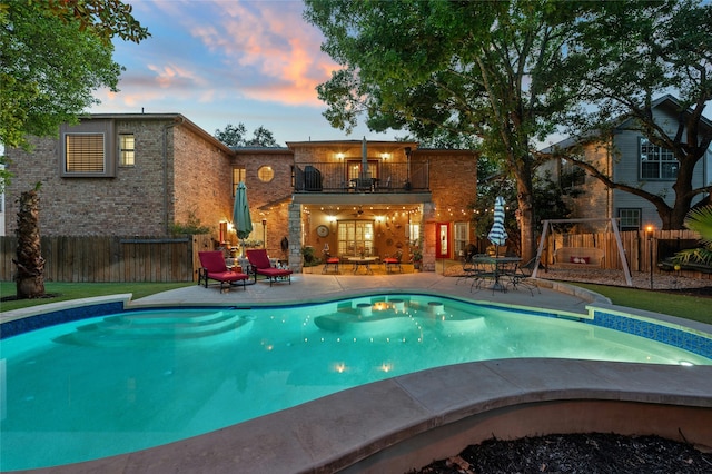 pool at dusk with a patio