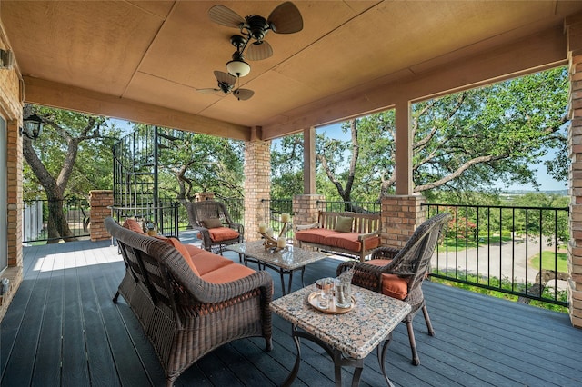 wooden deck with an outdoor hangout area and ceiling fan