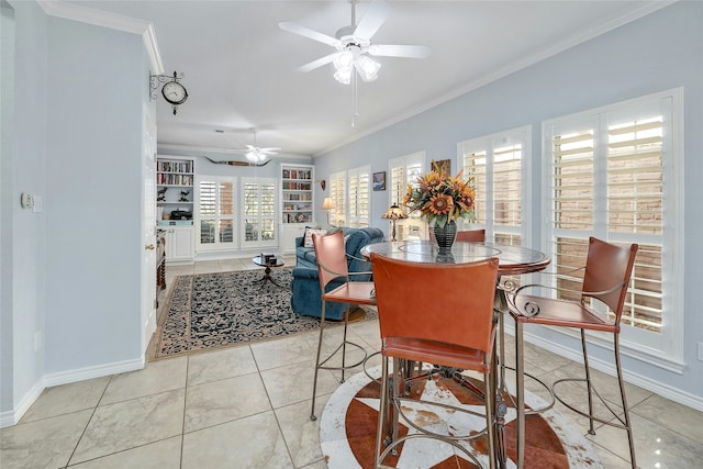 tiled dining area featuring ceiling fan, plenty of natural light, crown molding, and built in shelves