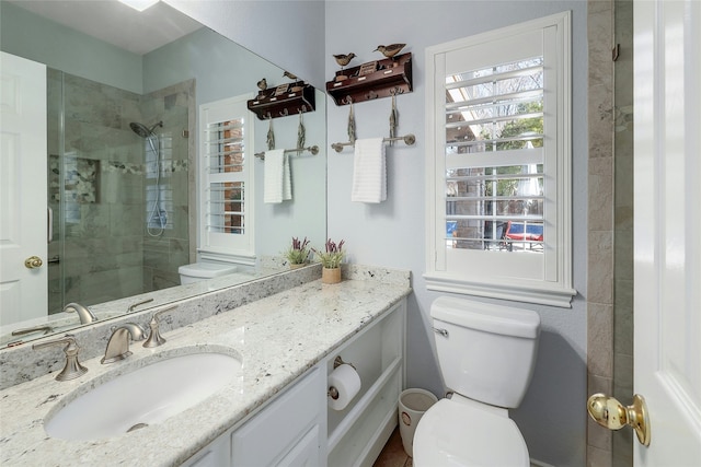 bathroom featuring toilet, walk in shower, and vanity