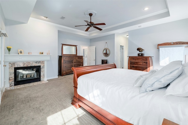 bedroom featuring a raised ceiling, a multi sided fireplace, crown molding, ceiling fan, and light carpet