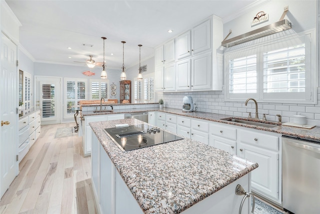 kitchen featuring black electric stovetop, a kitchen island, sink, white cabinetry, and stainless steel dishwasher