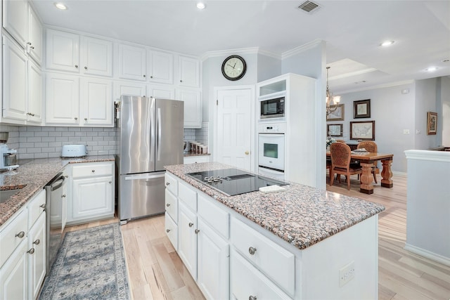 kitchen with light stone counters, light hardwood / wood-style flooring, a center island, black appliances, and white cabinetry