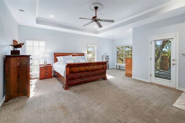 carpeted bedroom featuring access to outside, ceiling fan, a tray ceiling, and crown molding