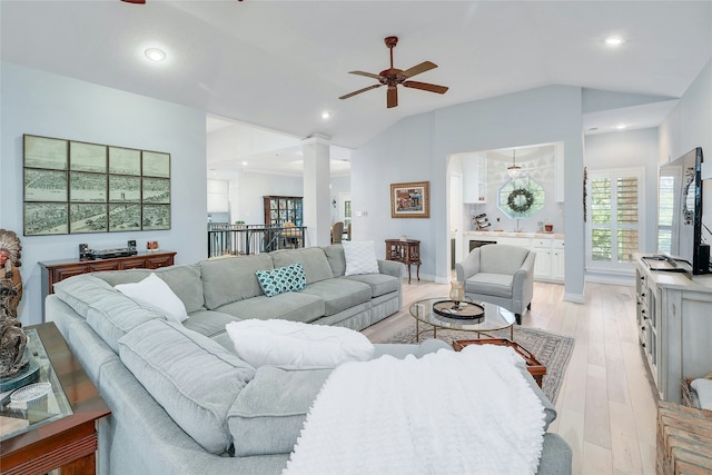 living room featuring light wood-type flooring, ceiling fan, and vaulted ceiling