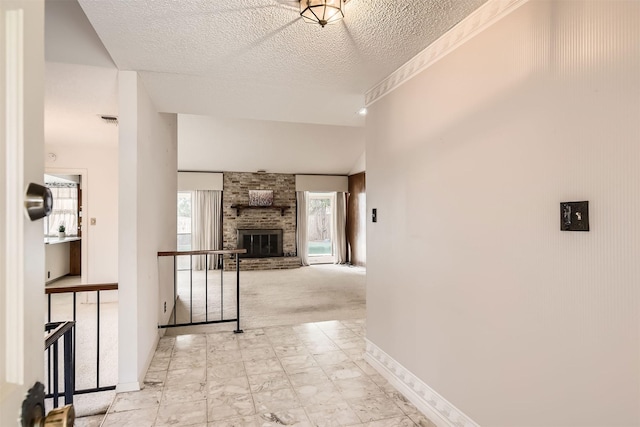 corridor with a textured ceiling and light carpet