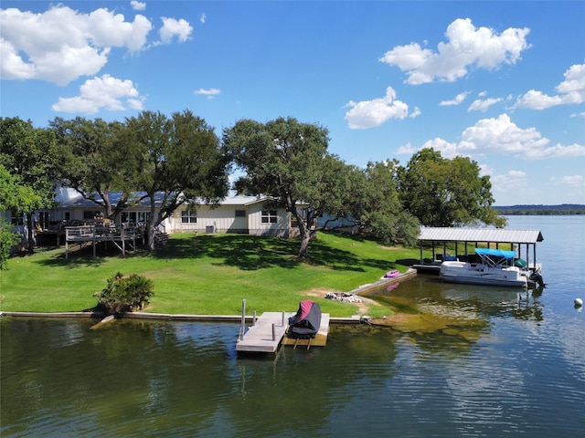 view of dock with a lawn and a water view