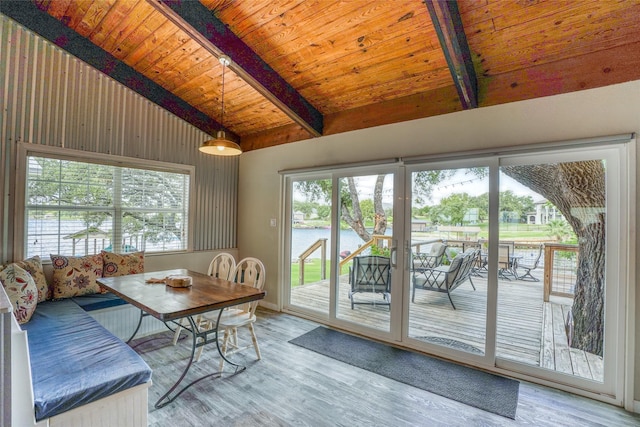 unfurnished dining area with wooden ceiling, beamed ceiling, a water view, light wood-type flooring, and wood walls