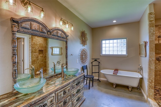 bathroom featuring a tub to relax in, vanity, and concrete flooring