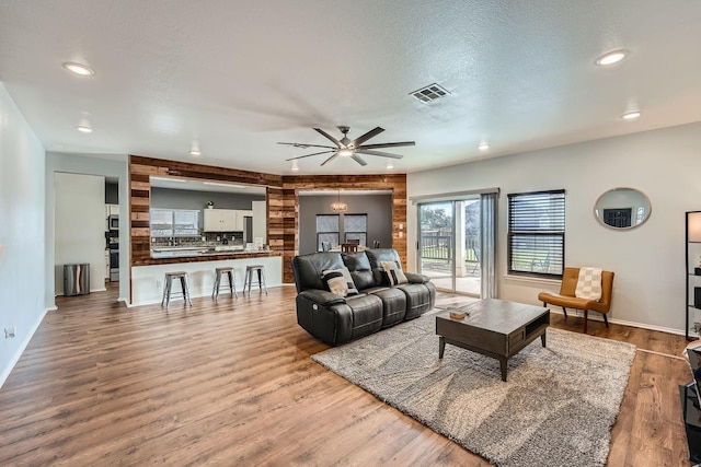 living room featuring a textured ceiling, ceiling fan, and hardwood / wood-style flooring