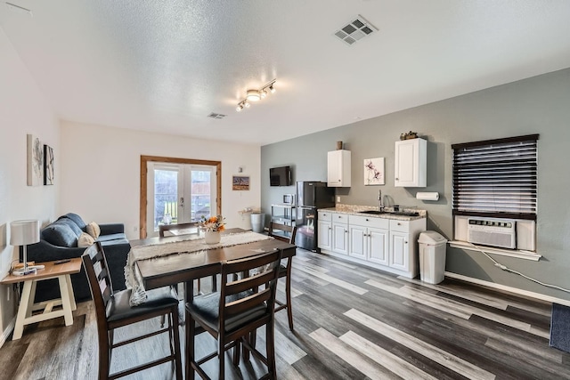 dining space featuring dark hardwood / wood-style flooring, french doors, a textured ceiling, cooling unit, and sink