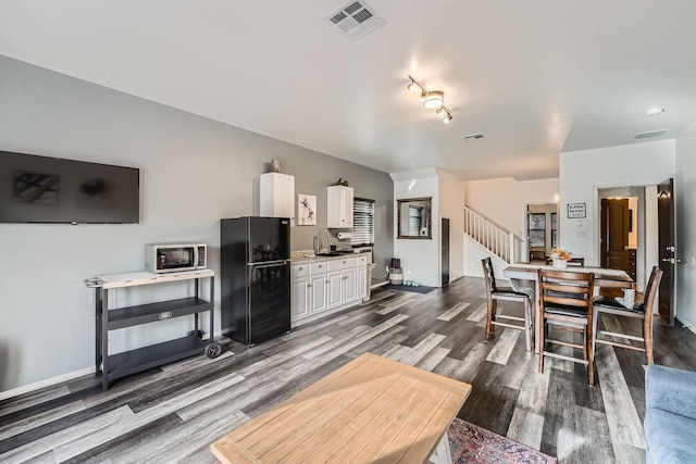 living room with dark hardwood / wood-style flooring and sink