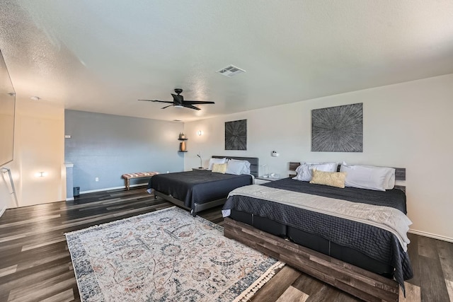 bedroom featuring ceiling fan, dark wood-type flooring, and a textured ceiling