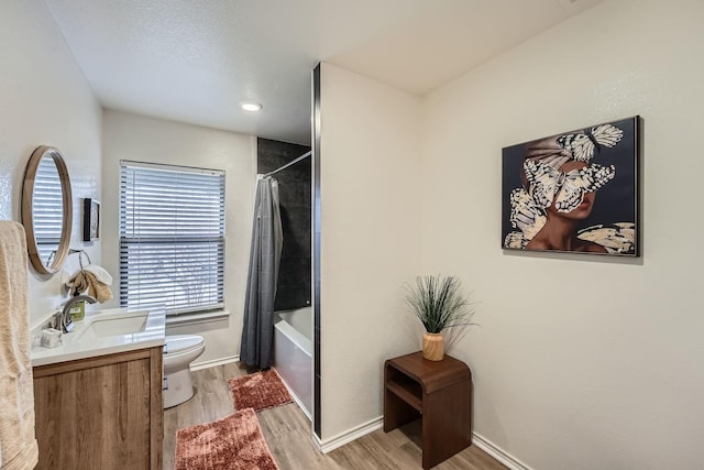 full bathroom with a textured ceiling, hardwood / wood-style flooring, toilet, shower / bath combination with curtain, and vanity