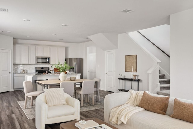 living room featuring sink and dark hardwood / wood-style floors