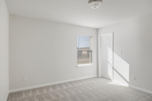 spare room featuring light colored carpet