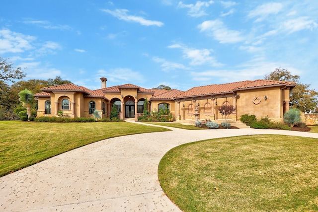 mediterranean / spanish-style house with a front yard